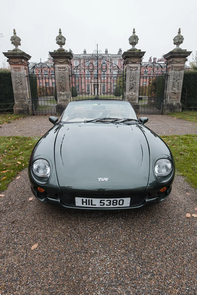 Dark-green TVR photographed outside a country house